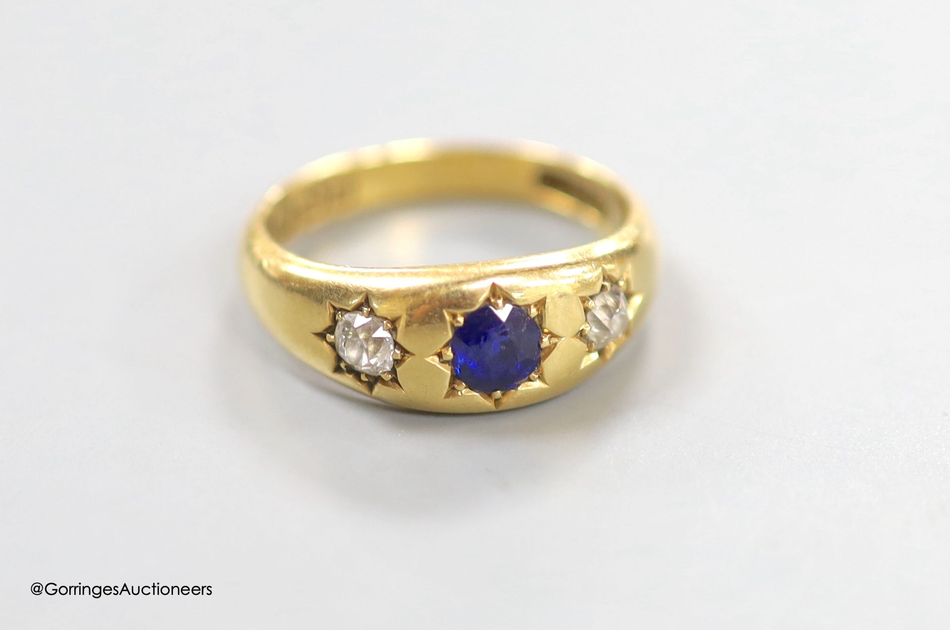 A late Victorian 18ct gold and gypsy set sapphire and diamond three stone ring, size N, gross 5.8 grams.